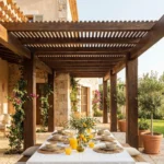 Pergola de madera de veta marcada con techado de lamas densas zona de comedor formal y arquitectura de piedra