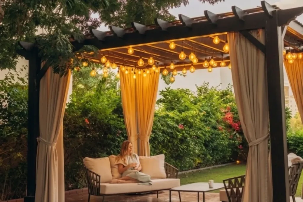 P&eacute;rgola elegante para jard&iacute;n con cortinas decorativas y luces c&aacute;lidas